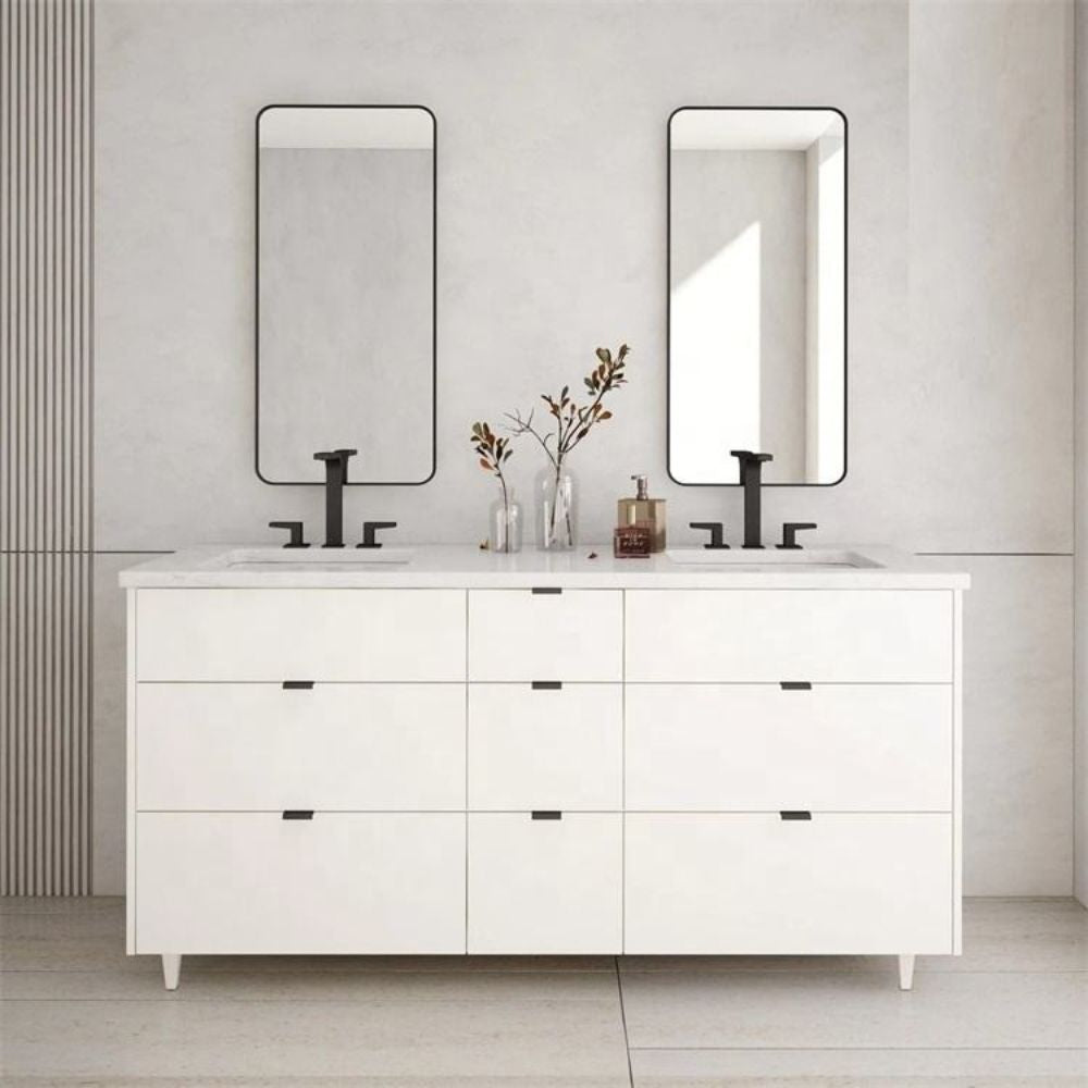 White bathroom vanity with two mirrors and decorative items on a light gray wall.