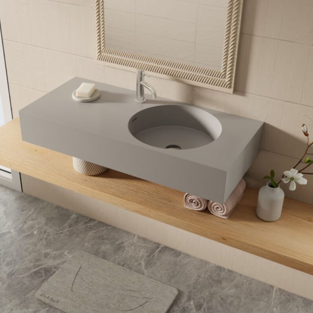 Bathroom with a concrete sink on a wooden vanity, featuring a mirror and decorative items.