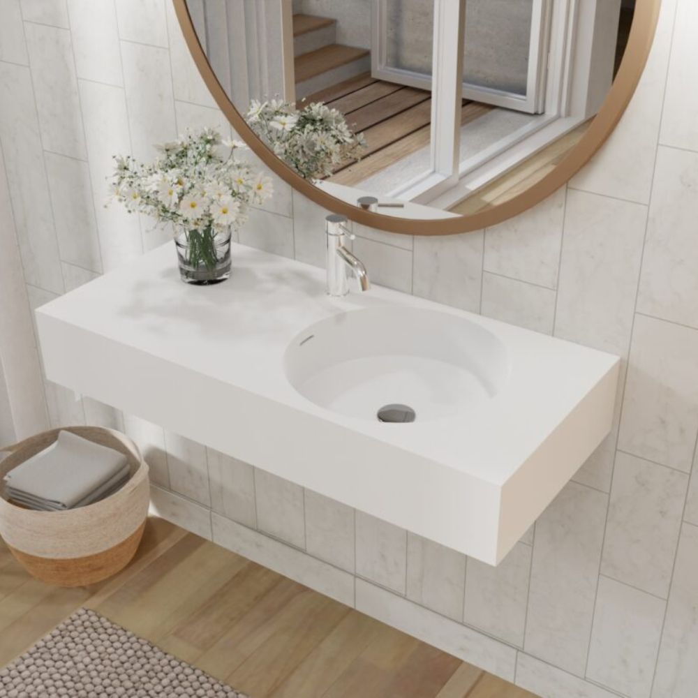 Bathroom with a white sink, round mirror, and decorative elements.
