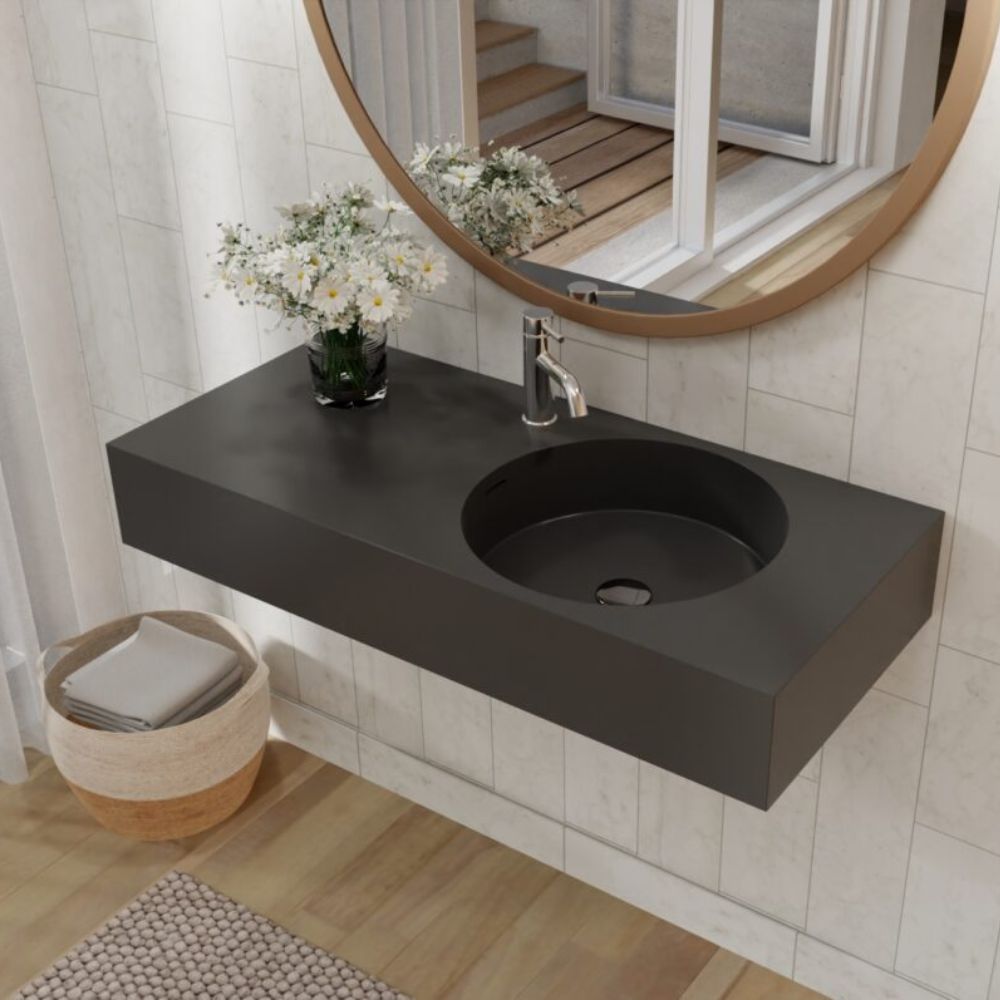 Bathroom with a black sink, mirror, and decorative elements.