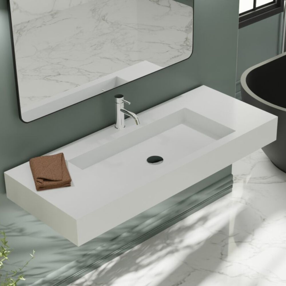 Modern bathroom sink with faucet and mirror in a marble-patterned room.