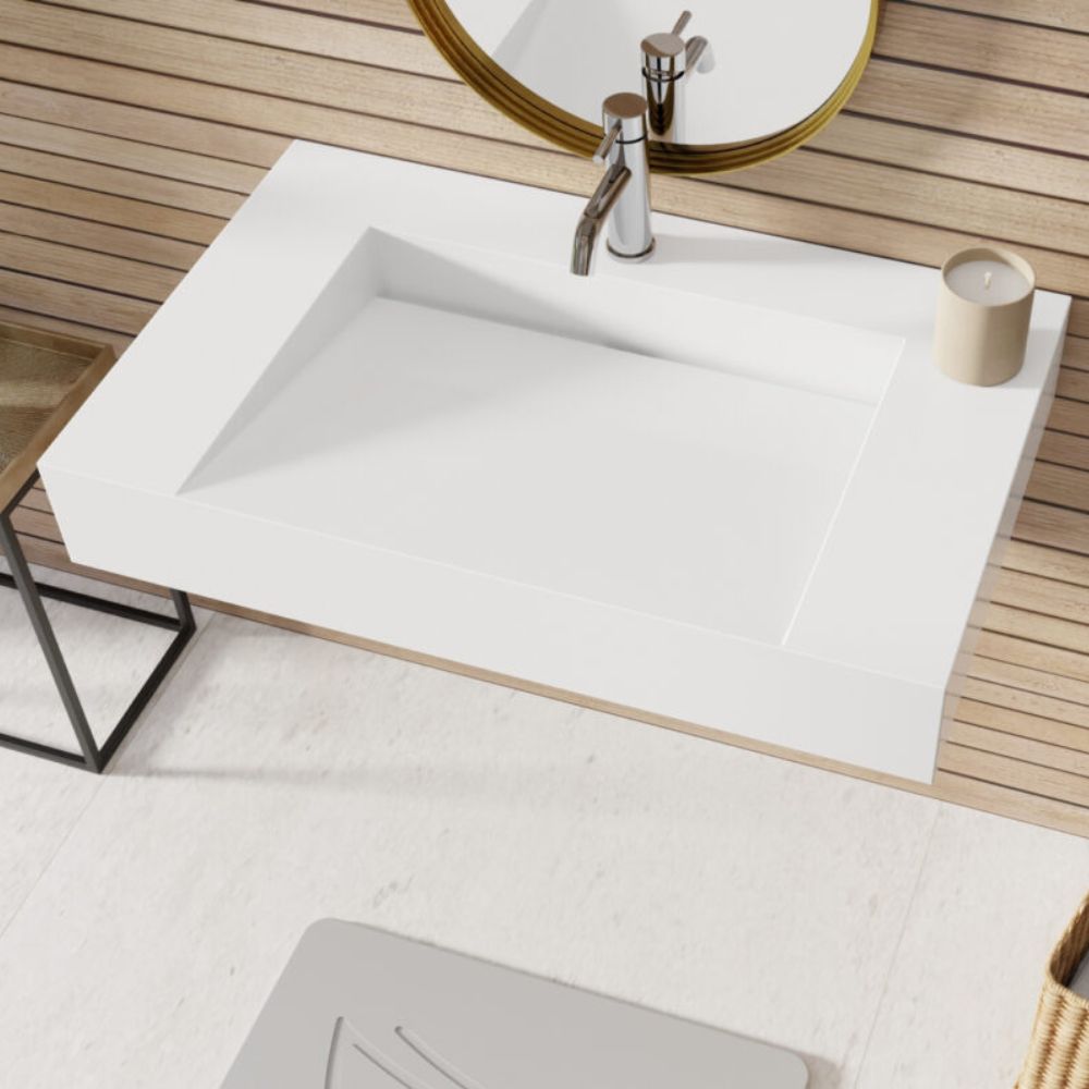 Modern bathroom setup with a white sink, faucet, and candle on a wooden floor.
