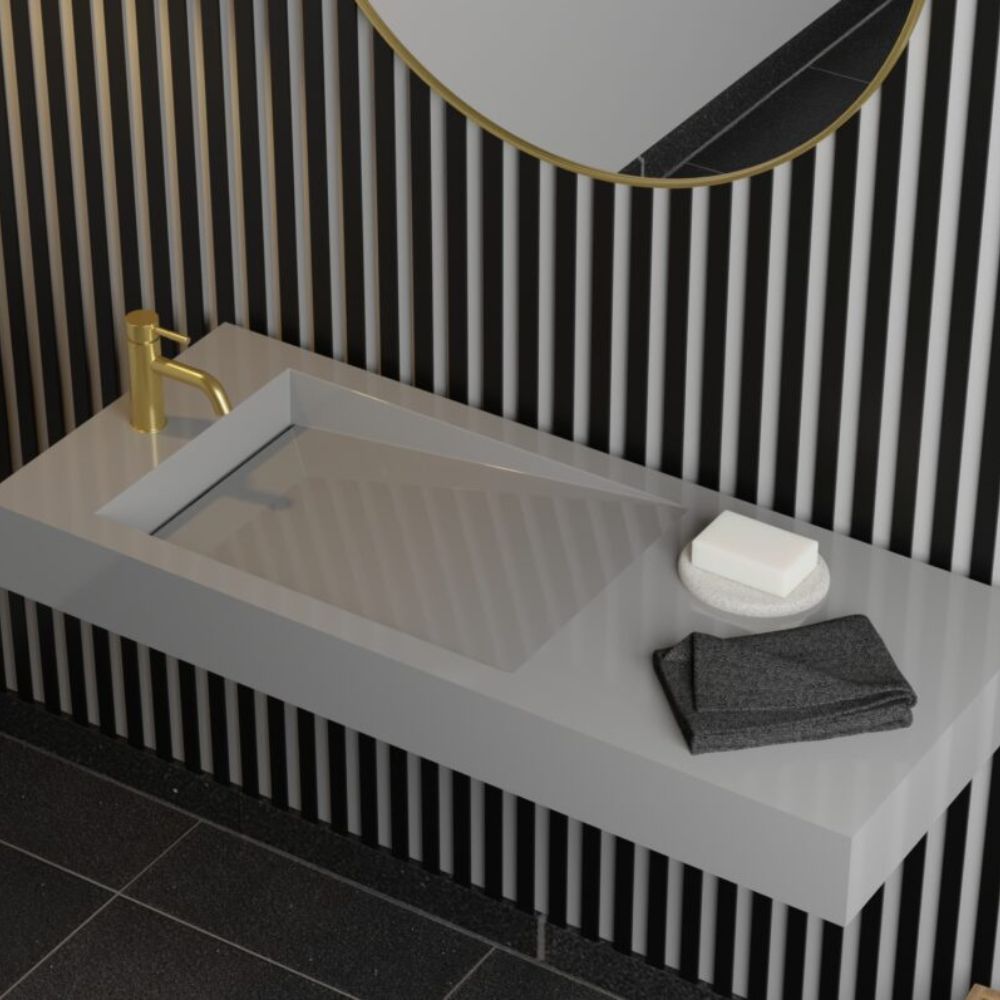 Bathroom sink with gold faucet, soap, and towel against a black and white striped wall.