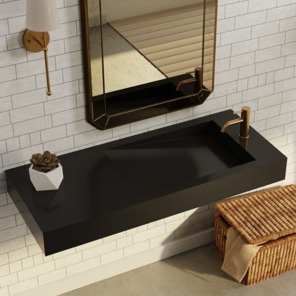 Modern bathroom vanity with black sink, gold faucet, and mirror on tiled wall.