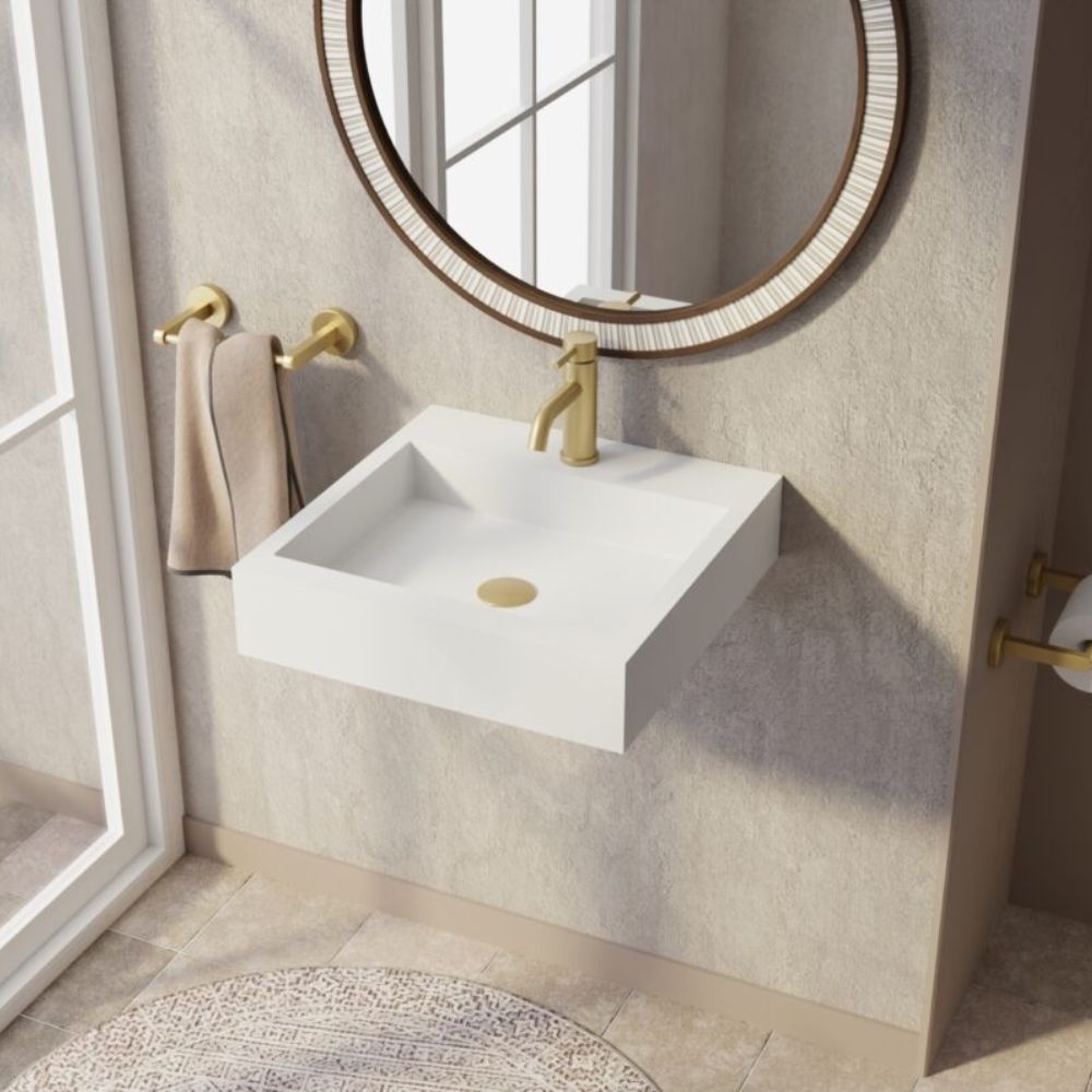 Bathroom with a white sink, gold faucet, and round mirror.