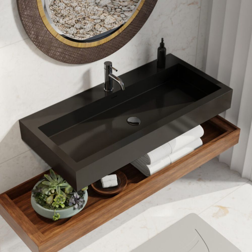 Bathroom vanity with black sink and wooden shelf, featuring a plant and toiletries.