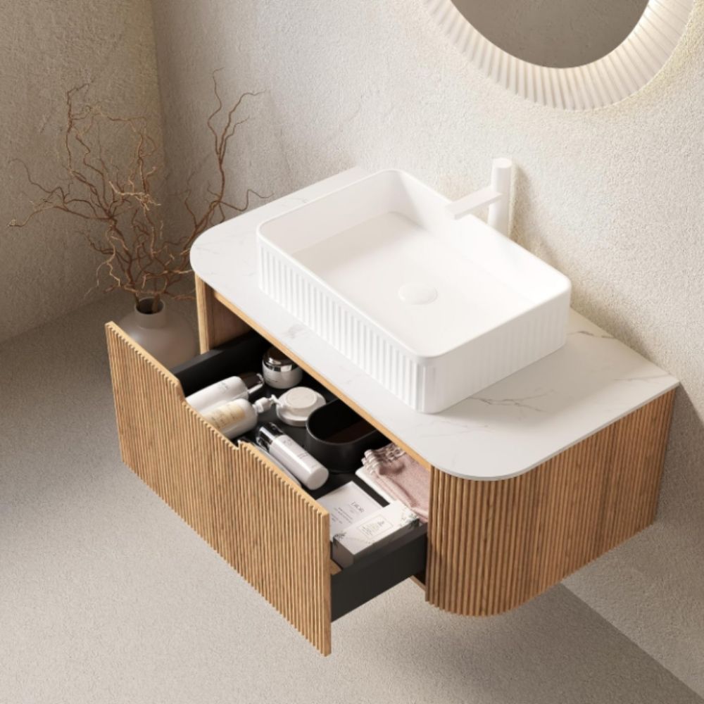 Bathroom vanity with open drawer containing toiletries, set against a neutral wall.