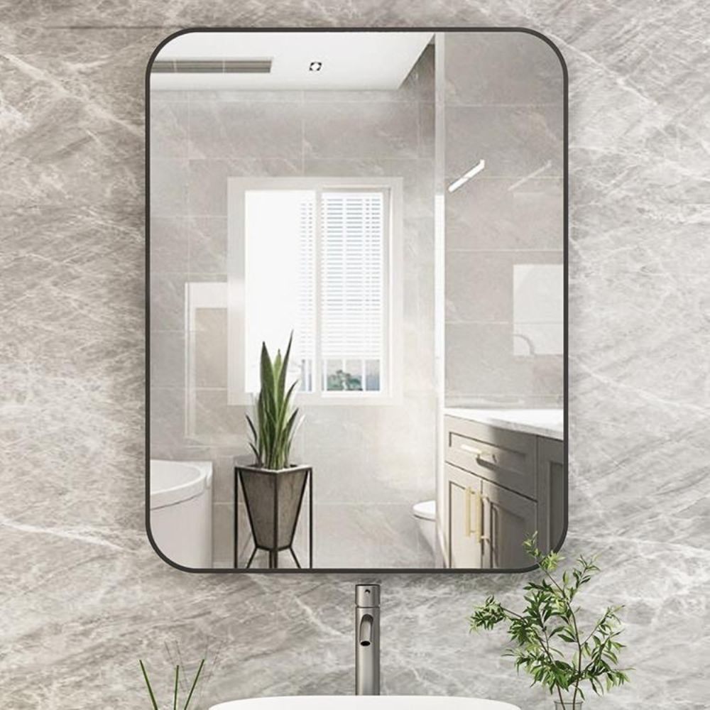 Bathroom mirror on a marble wall with a view of a bathroom.