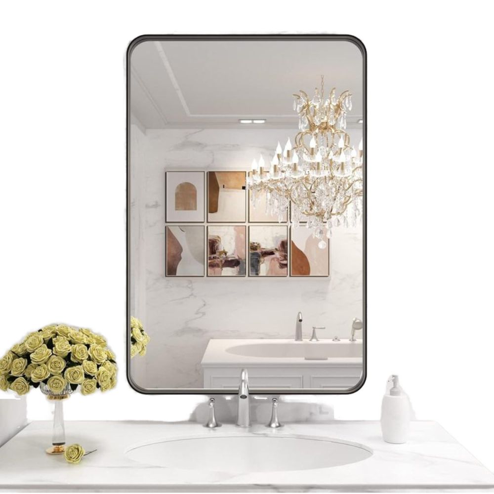 Bathroom interior with a large mirror reflecting a chandelier and wall art.
